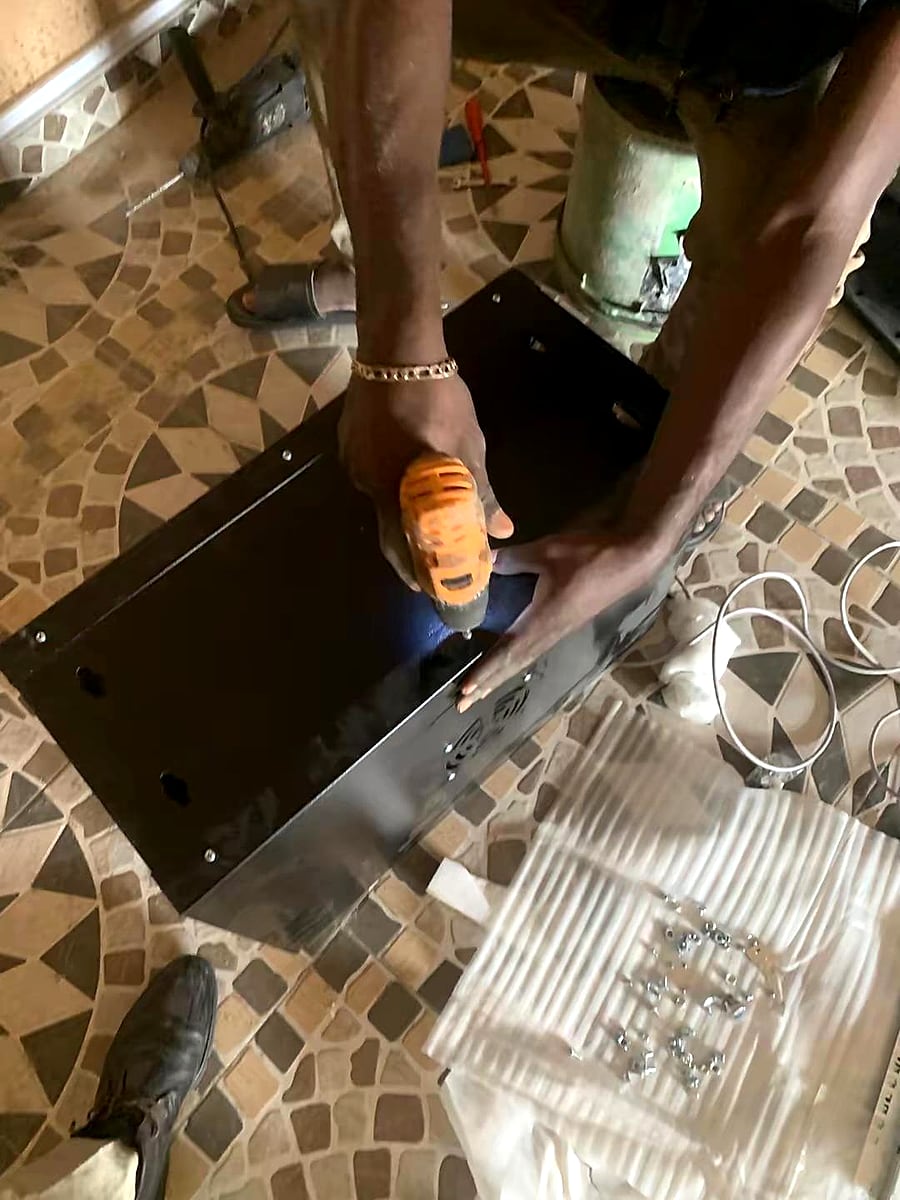 Technician drilling into a mounting surface for equipment placement.