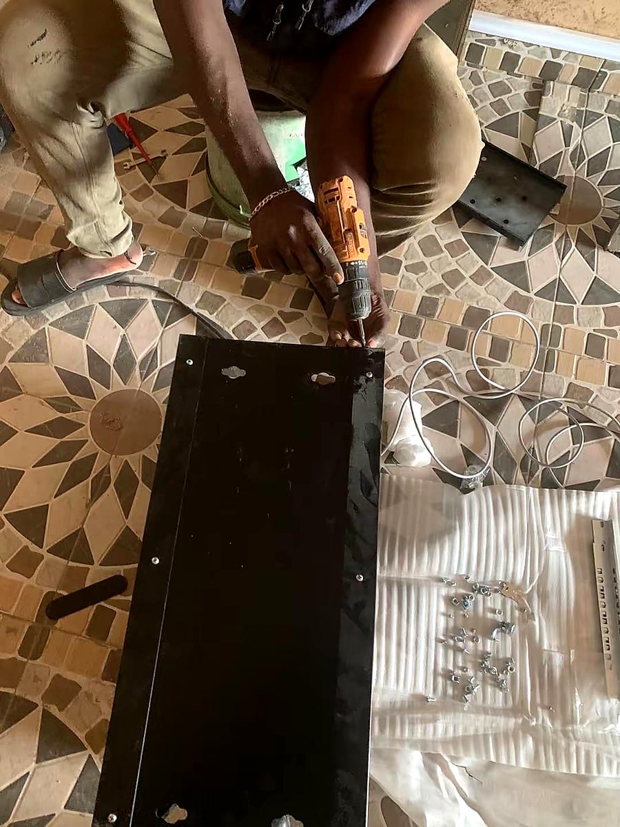 Hands preparing a rack panel and installation hardware on site.